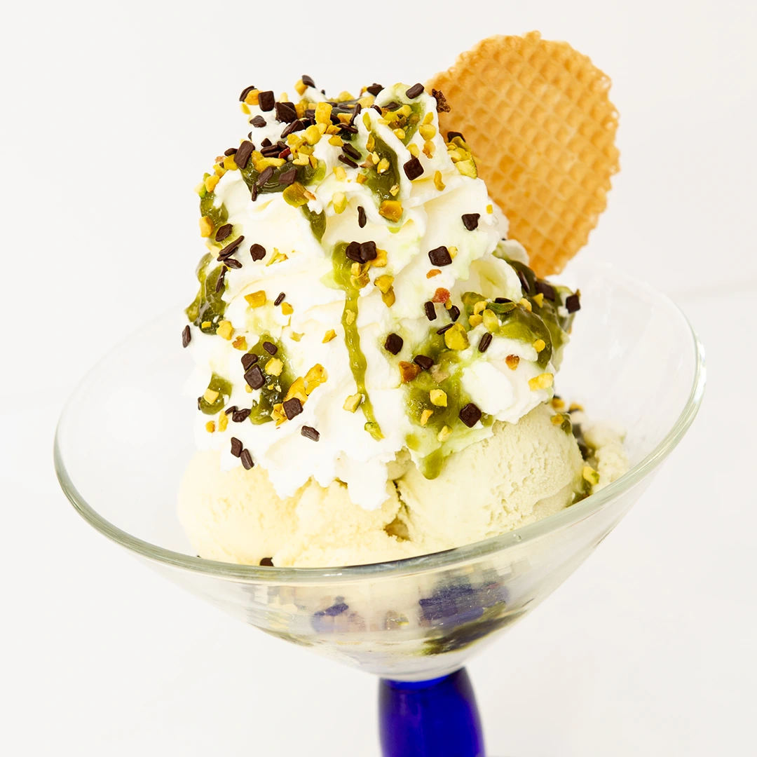 Coppa Gelato Oro Verde: composta con gelato al pistacchio e amarena, panna, granelli di pistacchi, scagliette di cioccolata, salsa al pistacchio.